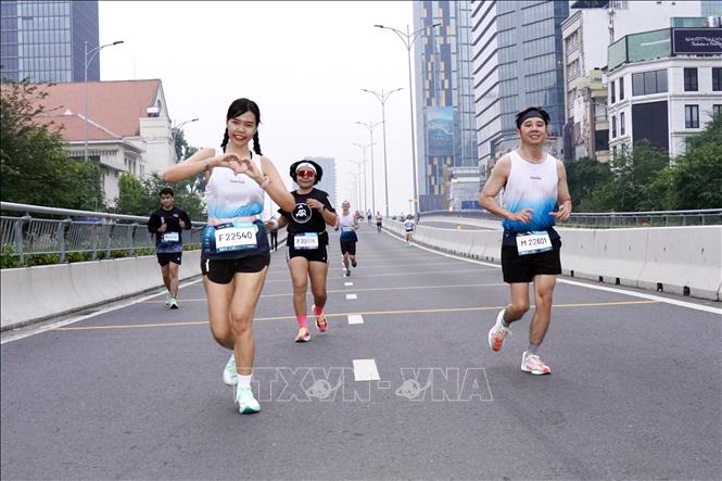 Các vận động viên phấn khởi thả dốc Cầu Ba Son, trước khi tăng tốc ở km cuối cùng. Ảnh: Trung Tuyến - TTXVN 