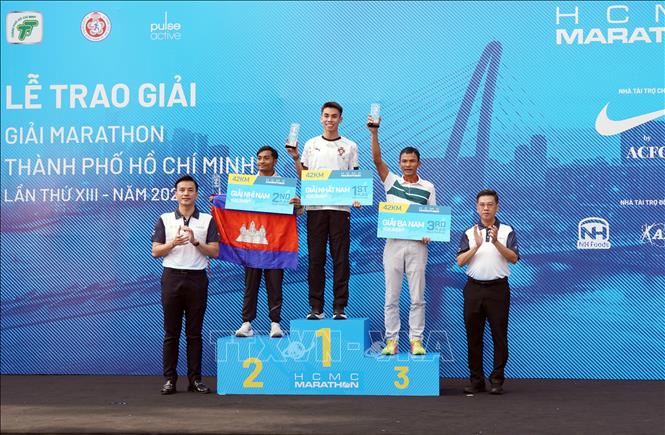 Ban Tổ chức trao giải cho các vận động viên nam chung cuộc, cự ly 42km. Ảnh: Trung Tuyến - TTXVN