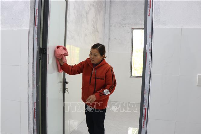 Người dân dọn dẹp, tái thiết cuộc sống mới trong những ngôi nhà mới xây ở Chiến dịch Quang Trung. Ảnh: Mai Trang - TTXVN