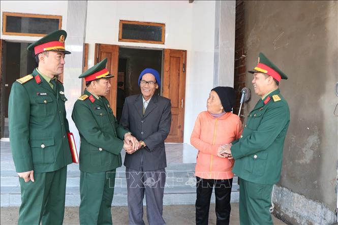 Đại tá Hà Văn Ái, Phó Chính ủy Bộ Chỉ huy Quân sự thành phố Huế (thứ 2, từ phải sang) thăm hỏi gia đình ông Trần Văn Viến (xã Khe Tre) trong ngôi nhà mới. Ảnh: Mai Trang- TTXVN 
