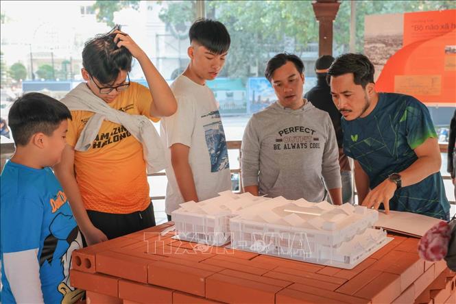 Người dân và du khách tìm hiểu về mô hình chợ Đồng Xuân được trưng bày tại Nhà Bát Giác. Ảnh: Hoàng Hiếu - TTXVN