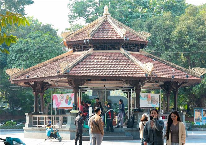 Người dân và du khách tìm hiểu thông tin về chợ Đồng Xuân thông qua mô hình, tài liệu, sách đang được trưng bày tại Nhà Bát Giác. Ảnh: Hoàng Hiếu - TTXVN 