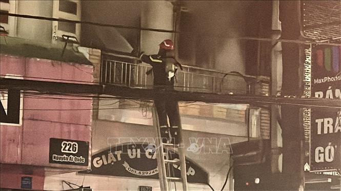 Lực lượng chức năng tỉnh Đồng Nai dùng thang tiếp cận đám cháy và giải cứu người đàn ông mắc kẹt. Ảnh: Lê Xuân-TTXVN