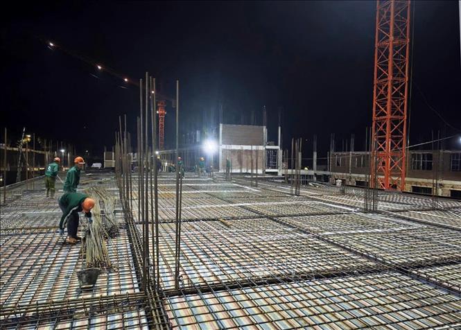 Nhằm đẩy nhanh tiến độ cũng như tính chất của từng hạng mục nên đơn vị thi công tăng ca, tăng kíp thi công cả ban đêm. Ảnh: Quý Trung – TTXVN