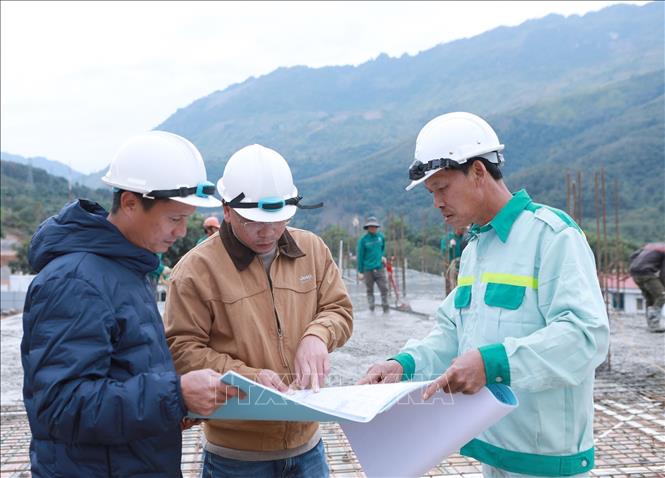Cán bộ kỹ thuật Ban Quản lý đầu tư xây dựng các công trình dân dụng và công nghiệp tỉnh Lai Châu phối hợp với đơn vị thi công luôn sát sao để dự án hoàn thành đảm bảo chất lượng công trình. Ảnh: Quý Trung – TTXVN 
