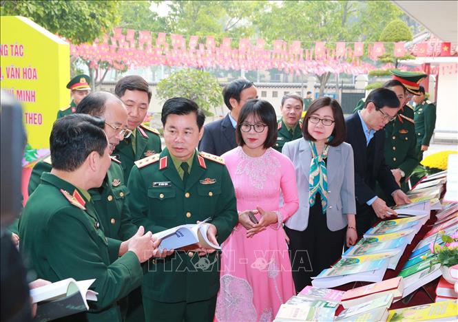 Thượng tướng Đỗ Xuân Tụng, Phó Chủ nhiệm Tổng cục Chính trị QĐND Việt Nam và các đại biểu tham quan khu trưng bày tài liệu, ấn phẩm, sách về Chủ tịch Hồ Chí Minh bên lề hội nghị. Ảnh: Trọng Đức - TTXVN
