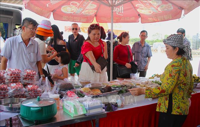 Du khách trải nghiệm ẩm thực tại bến Ninh Kiều. Ảnh: Nguyễn Hằng - TTXVN