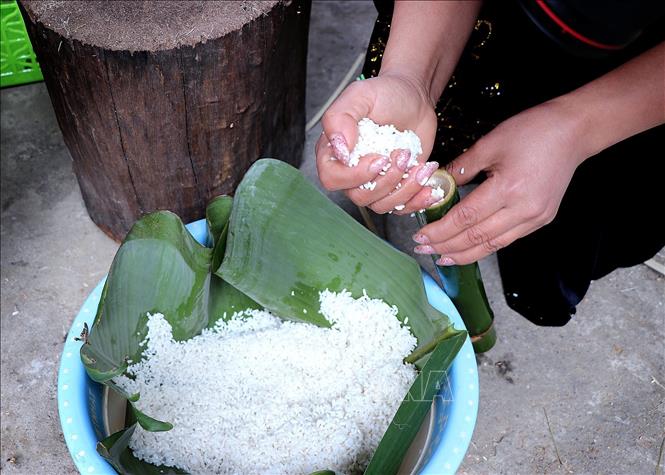 Cận cảnh công đoạn nhồi gạo nếp vào các ống tre, hóp hoặc nứa non. Ảnh: Thanh Hải - TTXVN