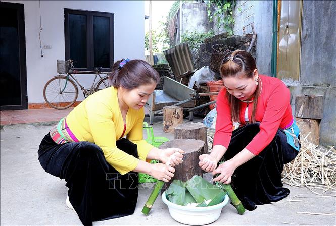 Gạo nếp được nhồi vào các ống tre, hóp hoặc nứa non để cho vào lò nướng. Ảnh: Thanh Hải - TTXVN 