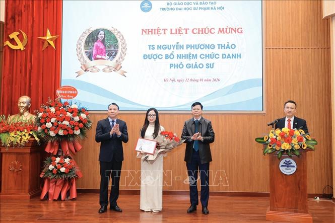 Lãnh đạo trường Đại học Sư phạm Hà Nội trao Quyết định và tặng hoa cho các tân Phó Giáo sư. Ảnh: Minh Quyết - TTXVN
