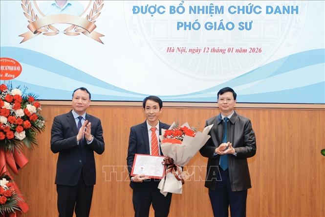 Lãnh đạo trường Đại học Sư phạm Hà Nội trao Quyết định và tặng hoa cho các tân Phó Giáo sư. Ảnh: Minh Quyết - TTXVN