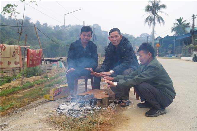 Dù đã thời điểm gần trưa, người dân ở các bản làng nằm dọc hai bên tuyến quốc lộ 16 qua địa bàn các xã Tri Lễ, Nhôn Mai (tỉnh Nghệ An) vẫn phải đốt lửa sưởi ấm do nền nhiệt giảm sâu, thời tiết lạnh giá. Ảnh: Xuân Tiến - TTXVN 