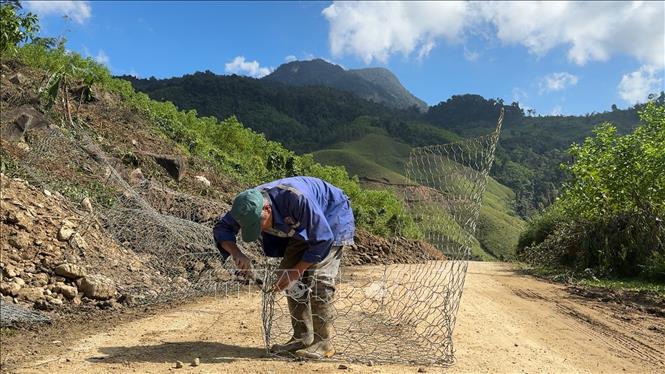 Đơn vị thi công đang triển khai đan rọ đá, để gia cố taluy tuyến đường Di Lăng – Trà Trung đoạn qua xã Tây Trà Bồng (Quảng Ngãi). Ảnh: Hải Âu-TTXVN.