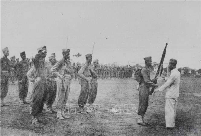 Hồ Chủ tịch trao cờ thêu dòng chữ “Trung với nước, hiếu với dân” cho học viên khóa I trường Lục quân Trần Quốc Tuấn (22/4/1946). Ảnh: Tư liệu TTXVN