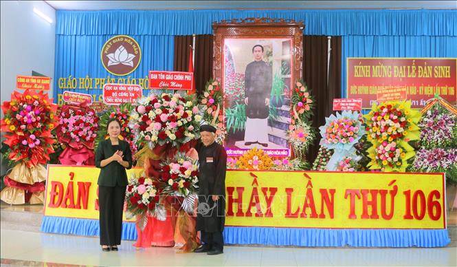 Bà Trần Thị Minh Nga, Phó Trưởng Ban Tôn giáo Chính phủ (trái) tặng hoa chúc mừng lễ kỷ niệm 106 năm Ngày Đản sinh Đức Huỳnh Giáo chủ Phật giáo Hòa Hảo. Ảnh: Công Mạo-TTXVN