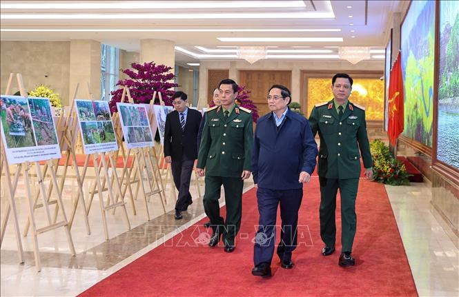 Thủ tướng Phạm Minh Chính tham quan trưng bày ảnh về kết quả khắc phục hậu quả bom mìn sau chiến tranh ở Việt Nam. Ảnh: Dương Giang-TTXVN 
