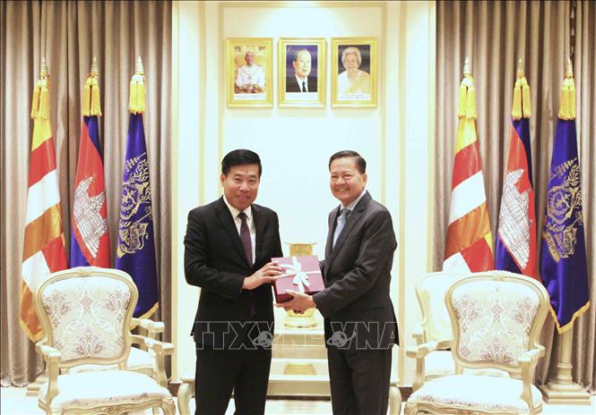 Ủy viên Trung ương Đảng, Thứ trưởng Bộ Ngoại giao Việt Nam Nguyễn Mạnh Cường (trái) và Phó Thủ tướng Campuchia Neth Savoeun trao đổi tặng phẩm lưu niệm. Ảnh: Hoàng Minh - PV TTXVN tại Campuchia 