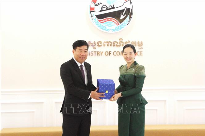 Bộ trưởng Bộ trưởng Thương mại Campuchia Cham Nimul (phải) và Ủy viên Trung ương Đảng, Thứ trưởng Bộ Ngoại giao Việt Nam Nguyễn Mạnh Cường trao đổi tặng phẩm lưu niệm. Ảnh: Hoàng Minh - PV TTXVN tại Campuchia 