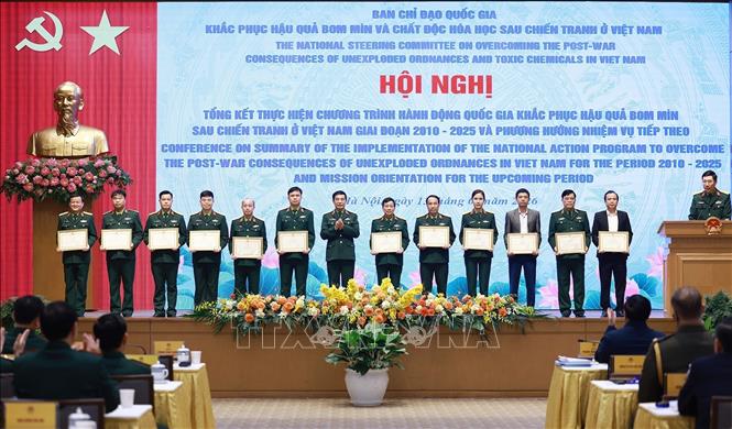 Đại tướng Phan Văn Giang, Bộ trưởng Bộ Quốc phòng tặng bằng khen cho các tập thể, cá nhân có thành tích xuất sắc trong thực hiện khắc phục hậu quả bom mìn sau chiến tranh ở Việt Nam. Ảnh: Dương Giang-TTXVN

