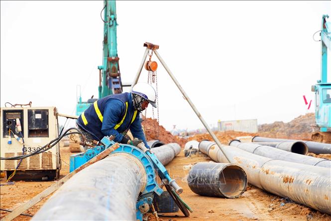 Công nhân thi công hệ thống đường ống dẫn nước. Ảnh: Hữu Quyết - TTXVN