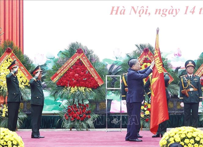 Tổng Bí thư Tô Lâm gắn Danh hiệu Anh hùng lực lượng vũ trang nhân dân lên Quân kỳ Quyết thắng của Tổng cục Hậu cần - Kỹ thuật. Ảnh: Thống Nhất – TTXVN