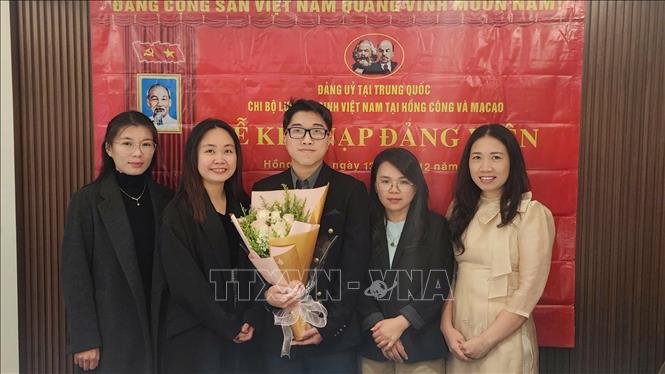 Nguyễn Thị Xuân Huệ (thứ hai, bên trái), nghiên cứu sinh chuyên ngành Ngôn ngữ học ứng dụng tiếng Anh tại Đại học Macau (Trung Quốc), Bí thư Chi bộ Lưu học sinh Việt Nam tại Hong Kong và Macau tại lễ kết nạp đảng viên mới. Ảnh: TTXVN phát
