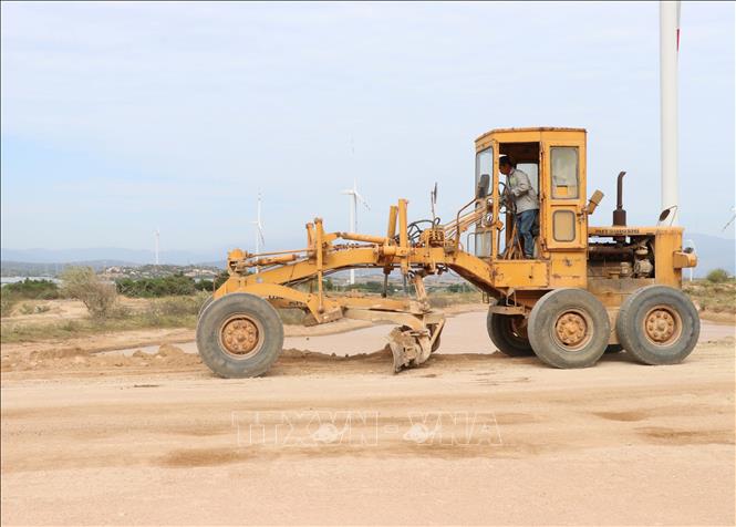 Rất ít phương tiện thông dụng thực hiện đầm nén, san lấp mặt đường từ quốc lộ 1 vào Cảng biển tổng hợp Cà Ná. Ảnh: Công Thử - TTXVN