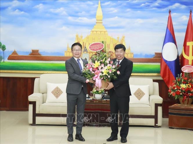 Thứ trưởng Bộ Ngoại giao Nguyễn Mạnh Cường tặng hoa chúc mừng Phó Ban Đối ngoại Trung ương Đảng Lào Valaxay Lengsavat. Ảnh: TTXVN phát