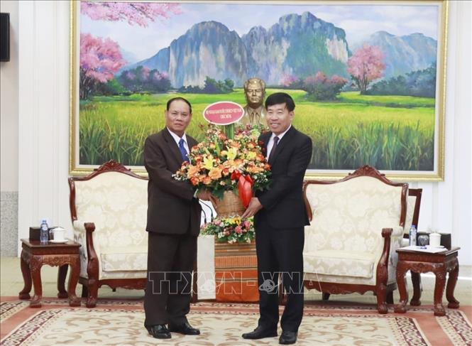 Thứ trưởng Bộ Ngoại giao Nguyễn Mạnh Cường tặng hoa chúc mừng Thường trực Ban Bí thư Lào Vilay Lakhamphong. Ảnh: TTXVN phát