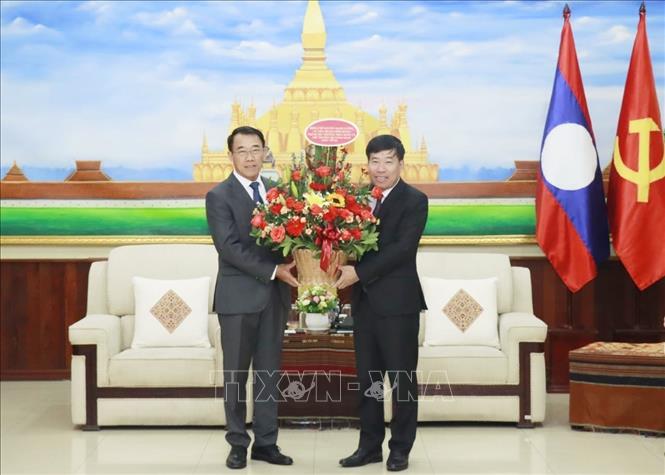 Thứ trưởng Bộ Ngoại giao Nguyễn Mạnh Cường tặng hoa chúc mừng Trưởng Ban Đối ngoại Trung ương Lào Bunleua Phandanouvong. Ảnh: TTXVN phát