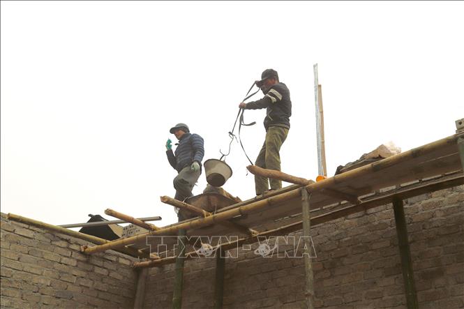 Dù điều kiện thời tiết giá lạnh, sương mù nhưng các công trình xây nhà mới cho người dân vùng lũ ở các bản trên địa bàn xã Nhôn Mai (tỉnh Nghệ An) vẫn được khẩn trương triển khai. Ảnh: Xuân Tiến - TTXVN 