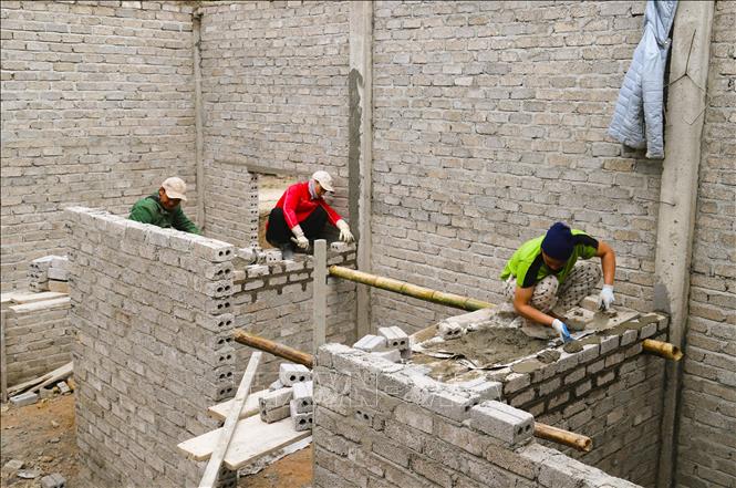 Đẩy nhanh tiến độ thi công xây nhà mới cho người dân vùng “tâm lũ” xã Nhôn Mai (tỉnh Nghệ An). Ảnh: Xuân Tiến - TTXVN 