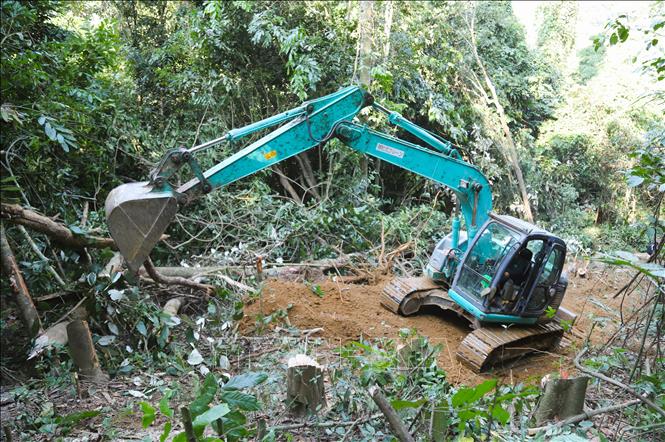Đơn vị thi công tập trung đang máy móc, nhân lực, phương tiện khai mở tuyến đường xuyên rừng vào Dự án xây dựng khu tái định cư ở bản Phá Mựt (xã Nhôn Mai, tỉnh Nghệ An) nhằm di dời khẩn cấp 16 hộ dân bị mất nhà ở hoàn toàn do lũ ống, lũ quét. Ảnh: Xuân Tiến - TTXVN 