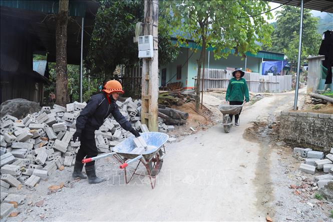 Phụ nữ các bản làng tham gia vận chuyển vật liệu xây dựng, hỗ trợ các gia đình bị thiệt hại trong bão lũ xây dựng nhà mới. Ảnh: Xuân Tiến - TTXVN 