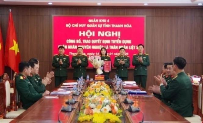 Thừa ủy quyền Bộ trưởng Bộ Quốc phòng và Bộ Tư lệnh Quân khu 4, Bộ Chỉ huy quân sự tỉnh Thanh Hoá trao Quyết định tuyển dụng quân nhân chuyên nghiệp cho chị Thiều Thị Oanh là thân nhân liệt sĩ. Ảnh: TTXVN phát 