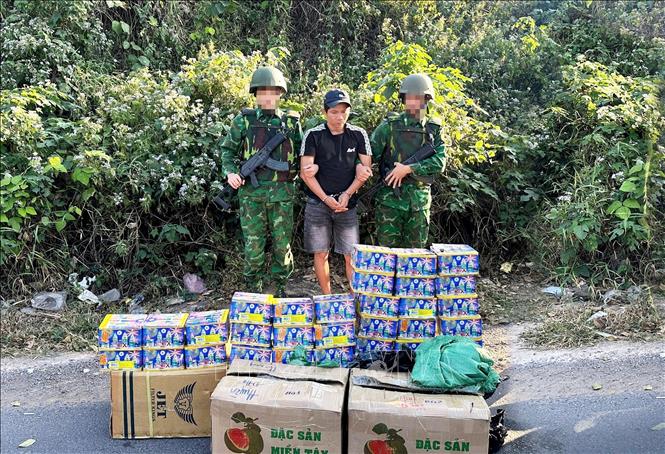 Đối tượng Trần Văn Bình và tang vật 30 hộp pháo hoa nổ bị lực lượng chức năng bắt giữ. Ảnh: TTXVN phát