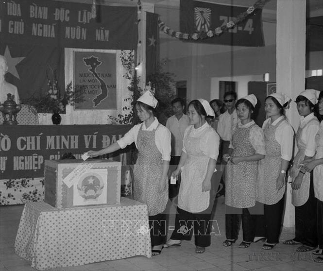 Ngày 25/4/1976, nhân dân khắp hai miền Bắc – Nam nô nức tham gia Tổng tuyển cử bầu Quốc hội, đánh dấu thắng lợi có ý nghĩa quyết định trên con đường tiến tới hoàn thành thống nhất đất nước về mặt nhà nước. Trong ảnh: 
Công nhân Nhà máy Dệt 8/3 (Hà Nội) bỏ phiếu bầu Quốc hội thống nhất năm 1976. Ảnh: TTXVN 