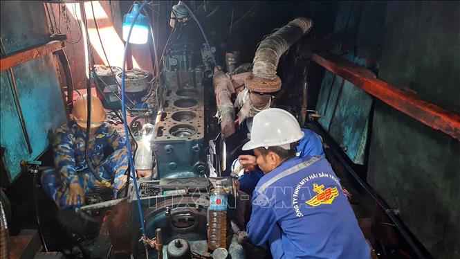 Cán bộ Trung tâm Dịch vụ Hậu cần - Kỹ thuật trên biển của Hải đoàn 129 Hải quân sửa chữa tàu cá cho ngư dân. Ảnh: TTXVN phát 