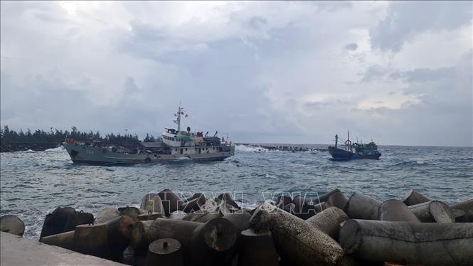 Tàu của Hải đoàn 129 Hải quân lai kéo tàu cá vào âu tàu của đơn vị để sửa chữa. Ảnh: TTXVN phát 