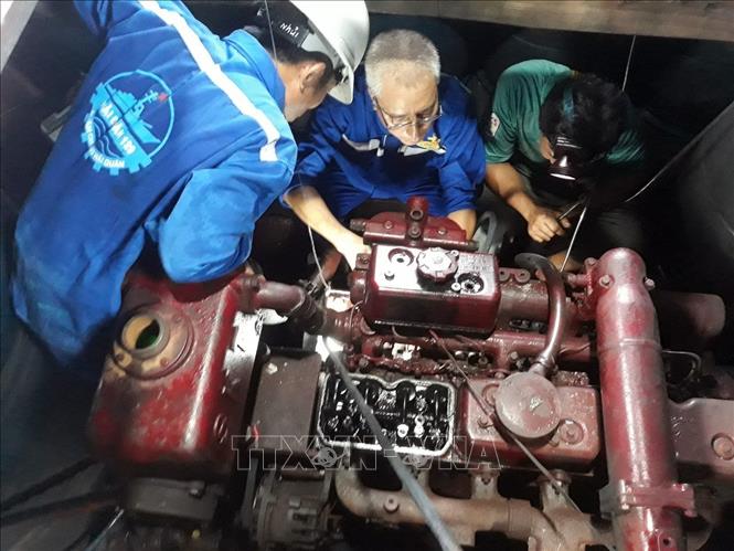 Cán bộ Trung tâm Dịch vụ Hậu cần - Kỹ thuật trên biển của Hải đoàn 129 Hải quân sửa chữa tàu cá cho ngư dân. Ảnh: TTXVN phát 