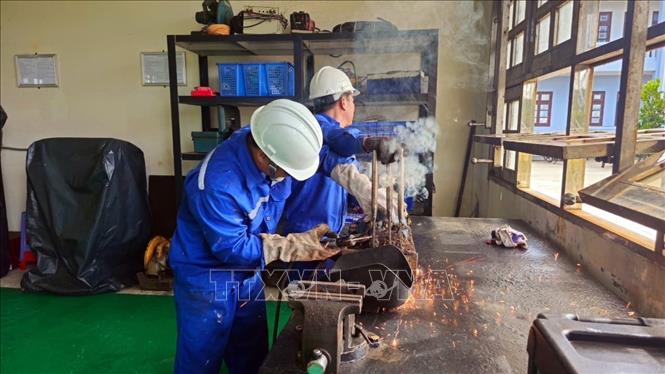 Cán bộ Trung tâm Dịch vụ Hậu cần - Kỹ thuật trên biển của Hải đoàn 129 Hải quân sửa chữa tàu cá cho ngư dân. Ảnh: TTXVN phát 