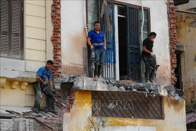 Một nhóm thợ xây dựng sử dụng máy khoan để mở mặt tiền mới cho một ngôi nhà cũ. Ảnh: Vũ Quang – TTXVN