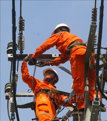Nhân viên Công ty Điện lực thành phố Cần Thơ duy tu, thay thế thiết bị phục vụ truyền dẫn điện nhằm tránh thất thoát điện năng tại xã Hỏa Lựu, thành phố Cần Thơ. Ảnh: Duy Khương – TTXVN