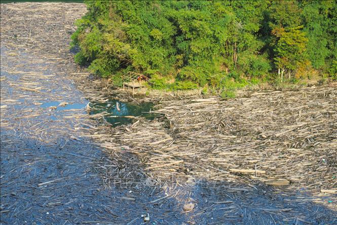 Nhiều địa điểm sông Nậm Nơn vặn mình, xâm thực vào kẻm núi thành vịnh nhỏ cũng biến thành bãi rác khổng lồ, dòng chảy bất động do bị ken cứng bởi rác, củi, thân gỗ, cành cây. Ảnh: Xuân Tiến - TTXVN 