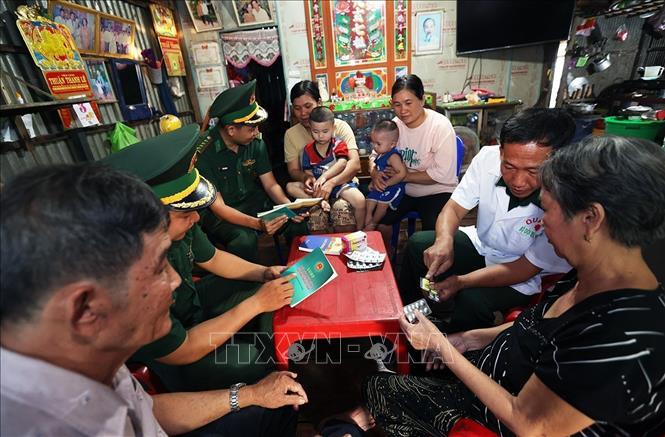 Bộ đội Biên phòng đồn Vĩnh Xương, tỉnh An Giang, tuyên truyền bảo an ninh Tổ quốc và thăm khám bệnh, cấp thuốc miễn phí ở hộ gia đình ông Lê Văn Sự, ấp 2, xã Vĩnh Xương. Ảnh: Vũ Sinh - TTXVN