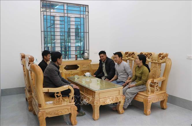 Gia đình anh Đèo Văn Tạ (áo xám) bản Hợp Nhất, xã Bản Bo (Lai Châu) vui mừng dọn vào ở ngôi nhà mới xây tại khu tái định cư. Ảnh: Nguyễn Oanh-TTXVN