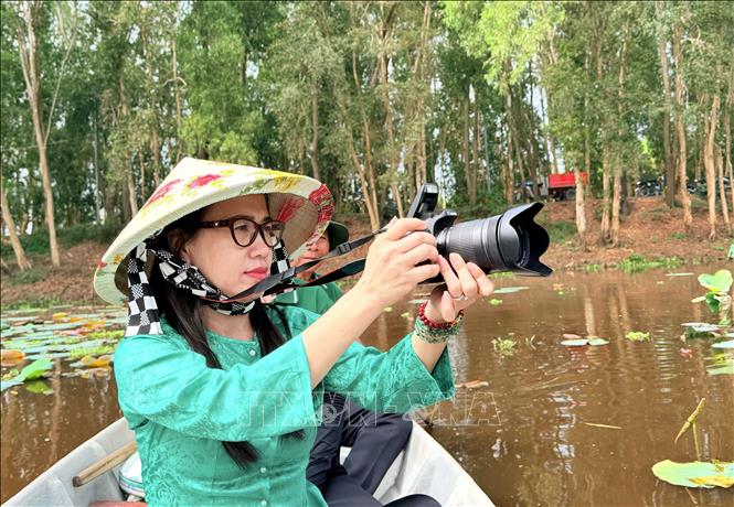 Du khách thích thú khám phá vẻ đẹp hoang sơ của rừng tràm. Ảnh: Thanh Sang- TTXVN