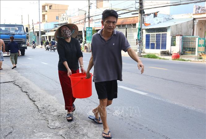 Người dân xã Đại Phước, tỉnh Đồng Nai phải dùng xô, chậu để lấy nước từ các điểm cấp nước tạm thời về phục vụ sinh hoạt. Ảnh: Lê Xuân-TTXVN