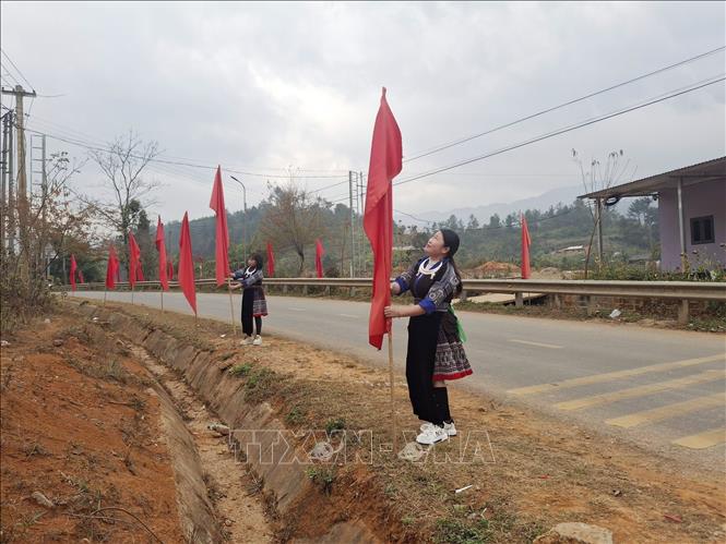 Người dân Púng Luông cắm cờ trên các tuyến đường với niềm tin, kỳ vọng về sự kiện trọng đại của đất nước. Ảnh: TTXVN phát
