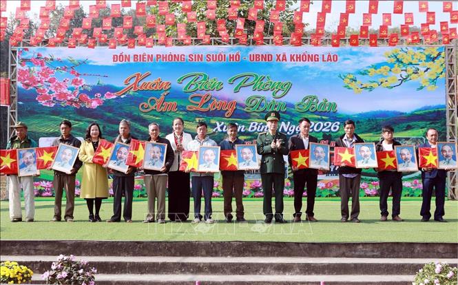 Trao tặng cờ Tổ quốc cùng ảnh Bác Hồ cho đồng bào các dân tộc bản Khổng Lào. Ảnh: Quý Trung – TTXVN